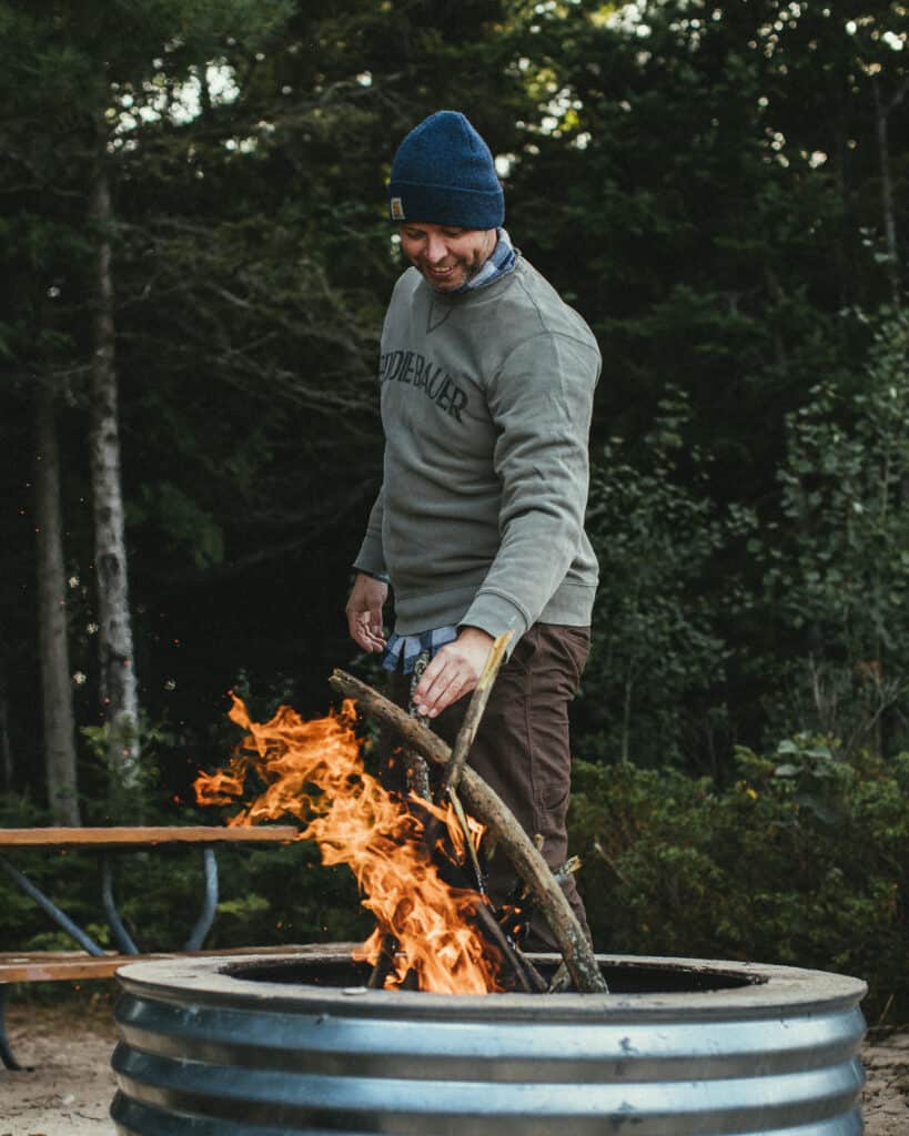 man starting a campfire