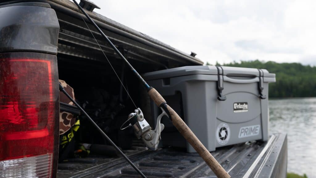 grizzly cooler on tailgate of pickup next to bass fishing gear