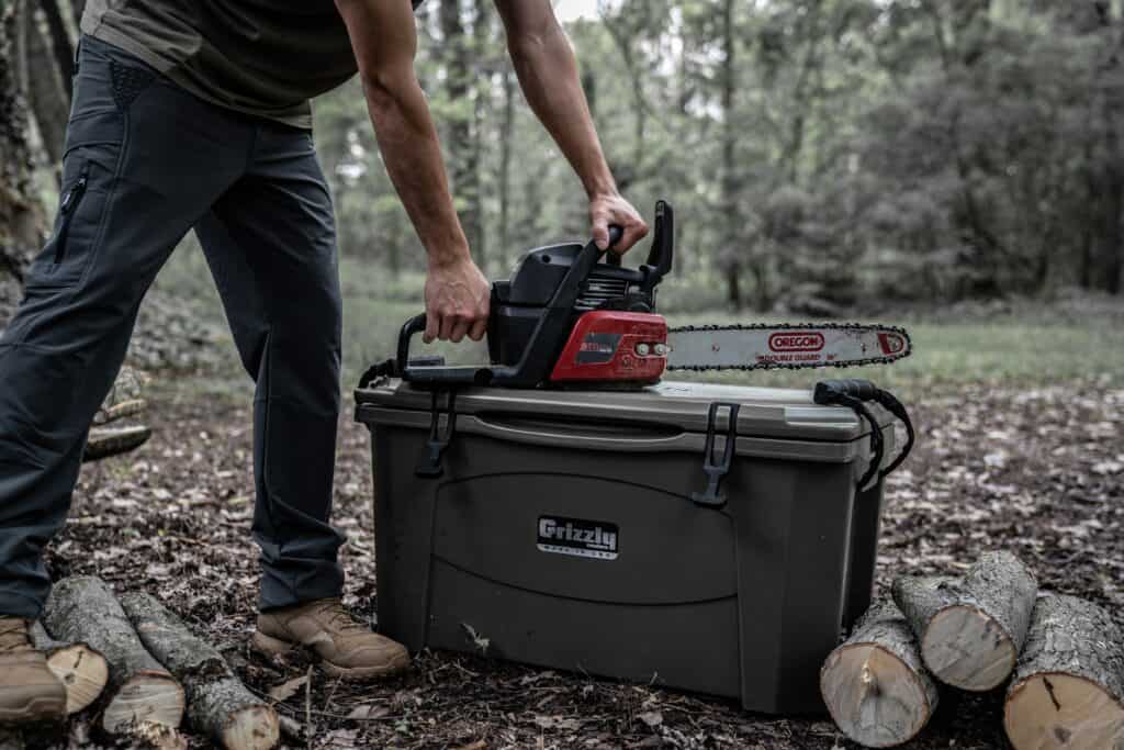 chainsaw sitting ontop of durable grizzly cooler
