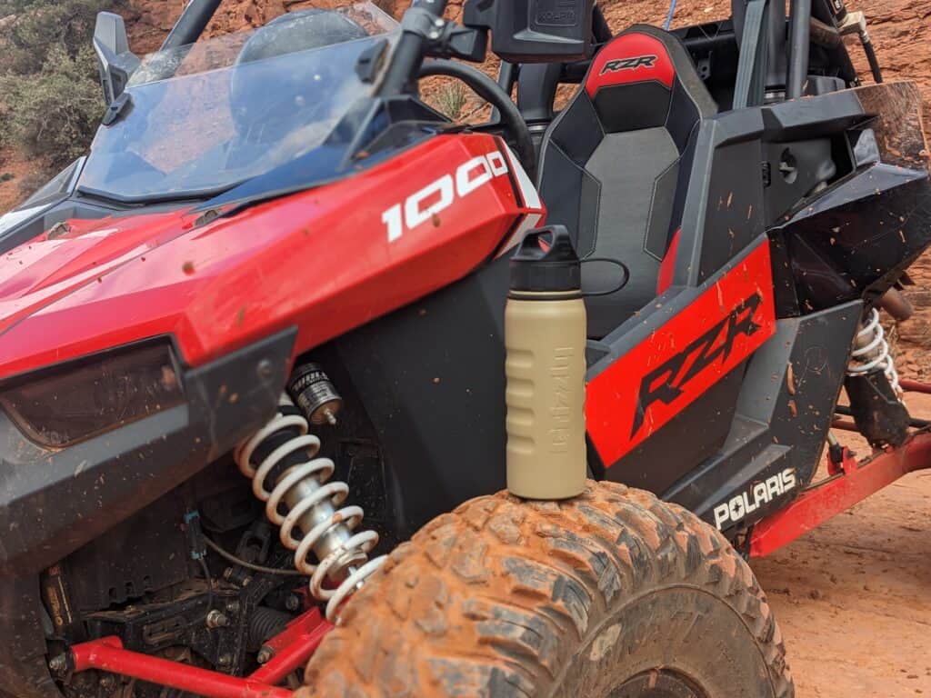 camping and hiking gear, grizzly water bottle sitting on wheel of ATV in Sedona, AZ
