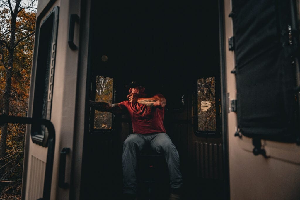 man sitting in elevated hunting blind testing the line of sight