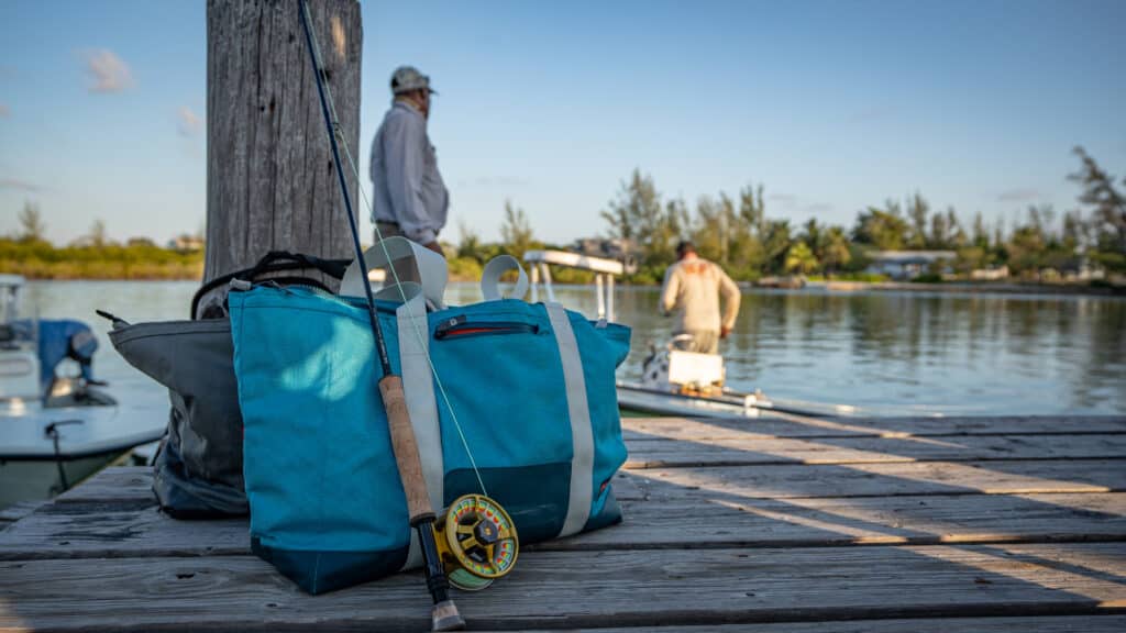 fly fishing rod and reel resting on a grizzly carryall cooler bag