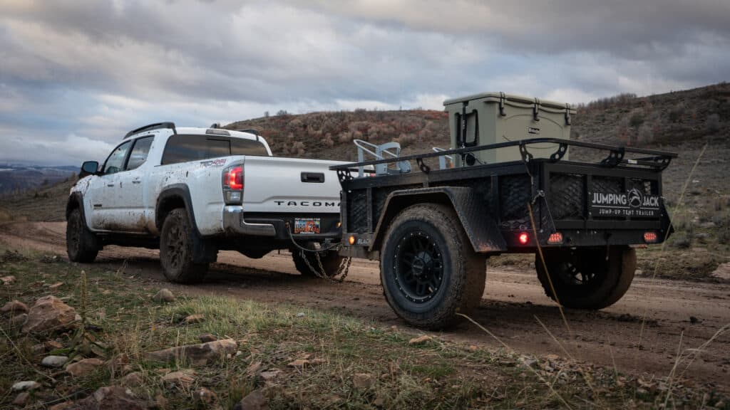 how to find elk, driving on trail with truck and trailer with grizzly 400 cooler on back of trailer.