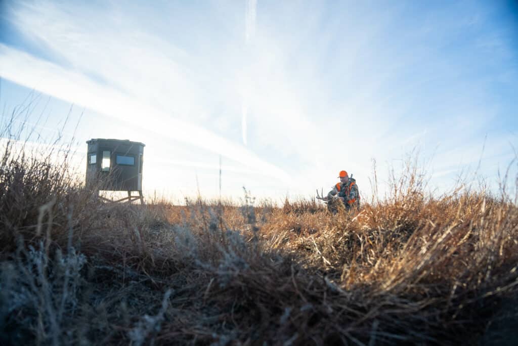 hunter with deer blind in background