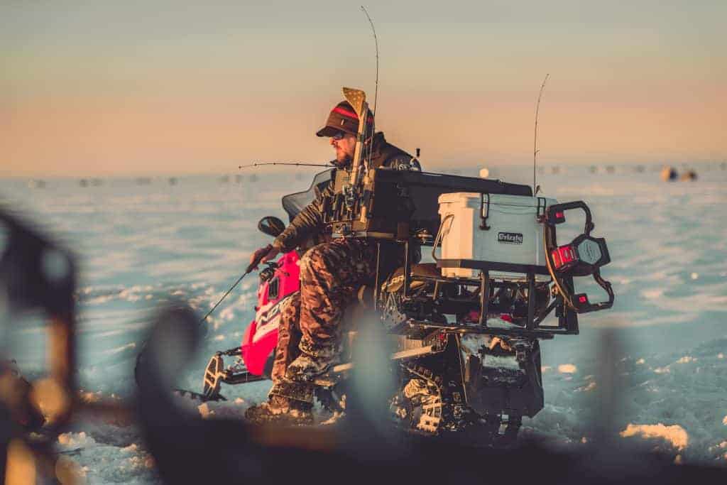 pro angler matt peters giving ice fishing tips while sitting on snow mobile