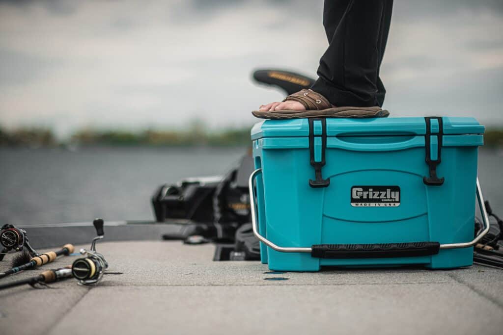 mille lacs lake fishing with matt peters standing on a teal grizzly 20 cooler on boat