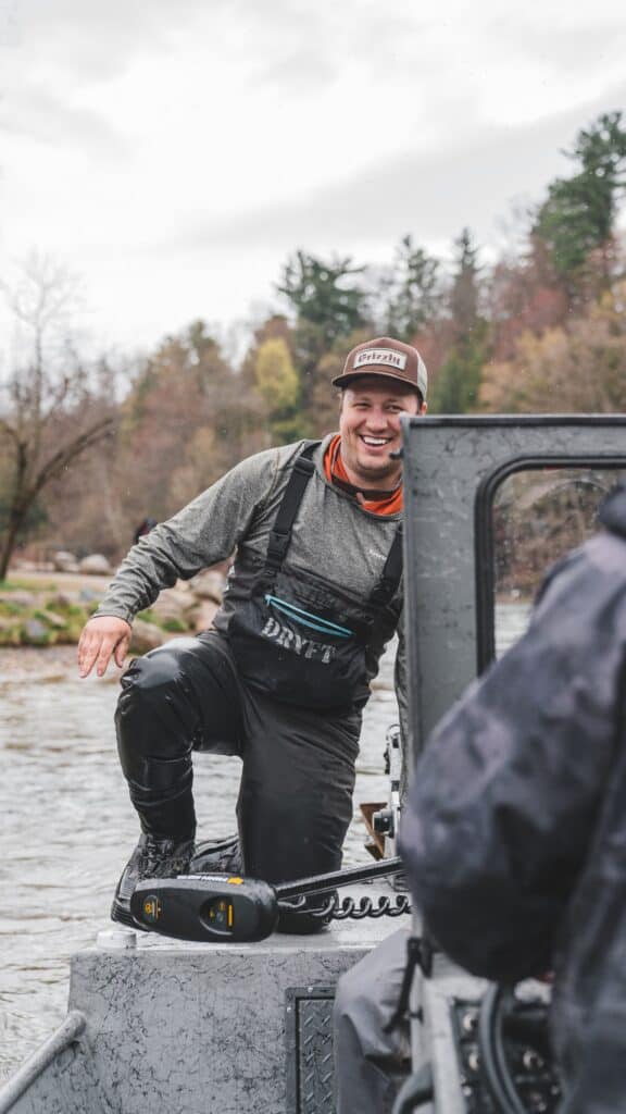 angler driving boat while steelhead fishing in michigan