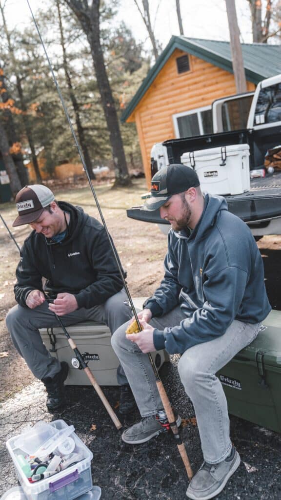 steelhead anglers sitting on grizzly coolers at camp