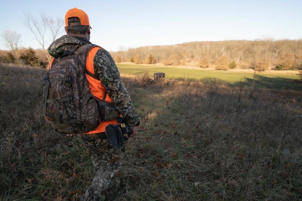 hunter walking down a hill towards hunting blind